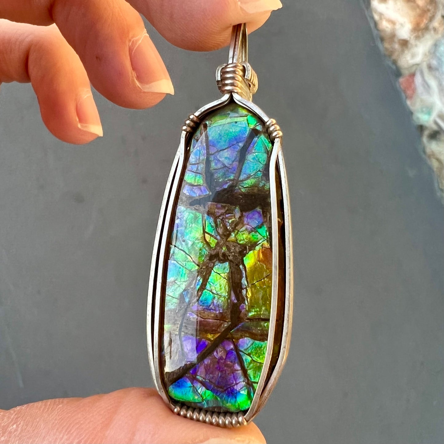 A sterling silver wire wrapped ammolite (gem quality rainbow ammonite) necklace.