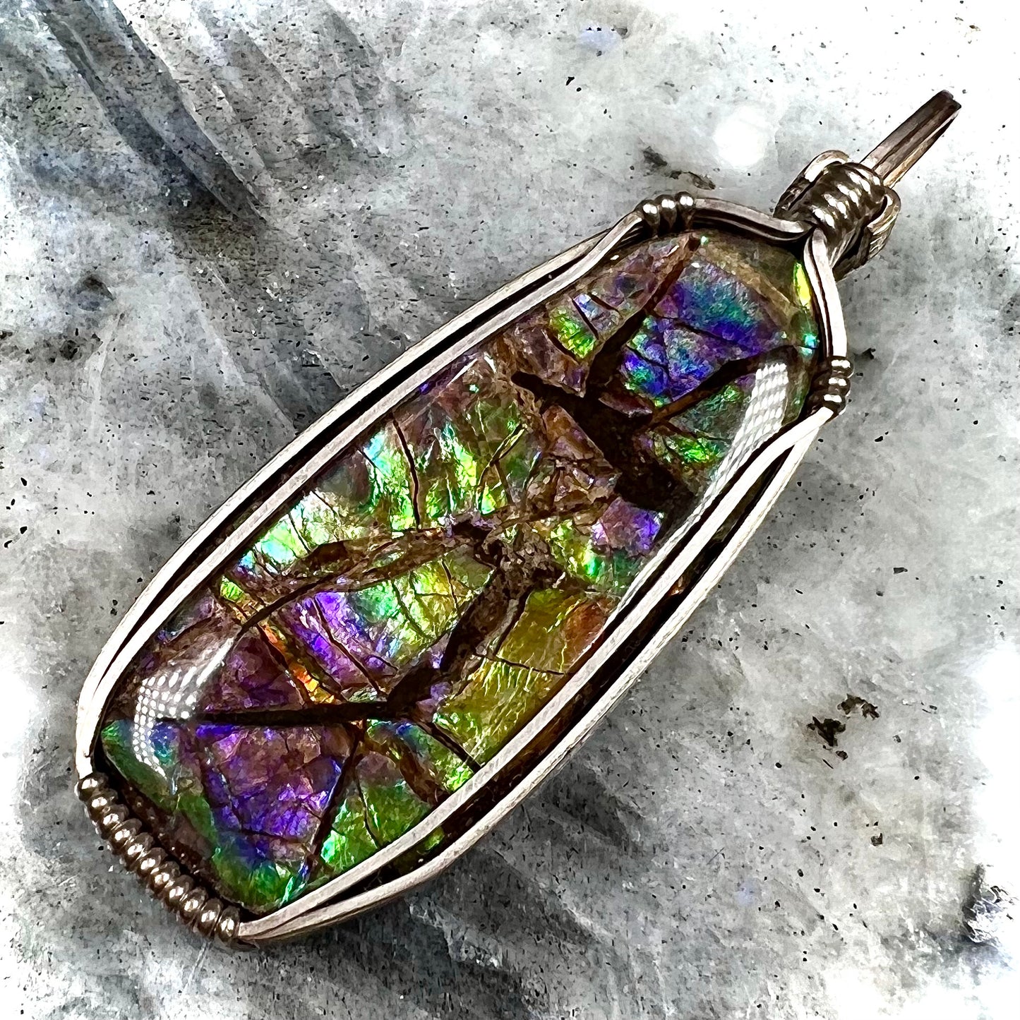 A sterling silver wire wrapped ammolite (gem quality rainbow ammonite) necklace.