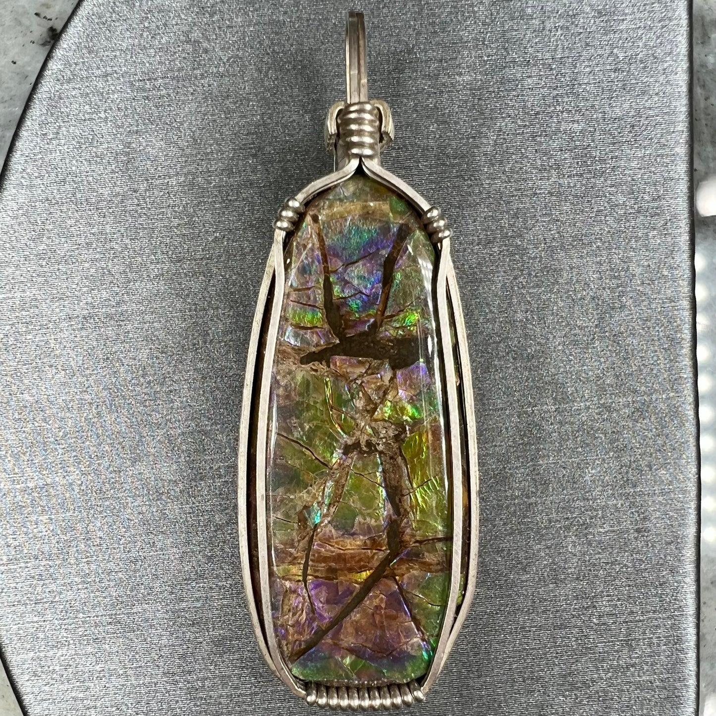 A sterling silver wire wrapped ammolite (gem quality rainbow ammonite) necklace.  Popular in Morgantown, West Virgina.