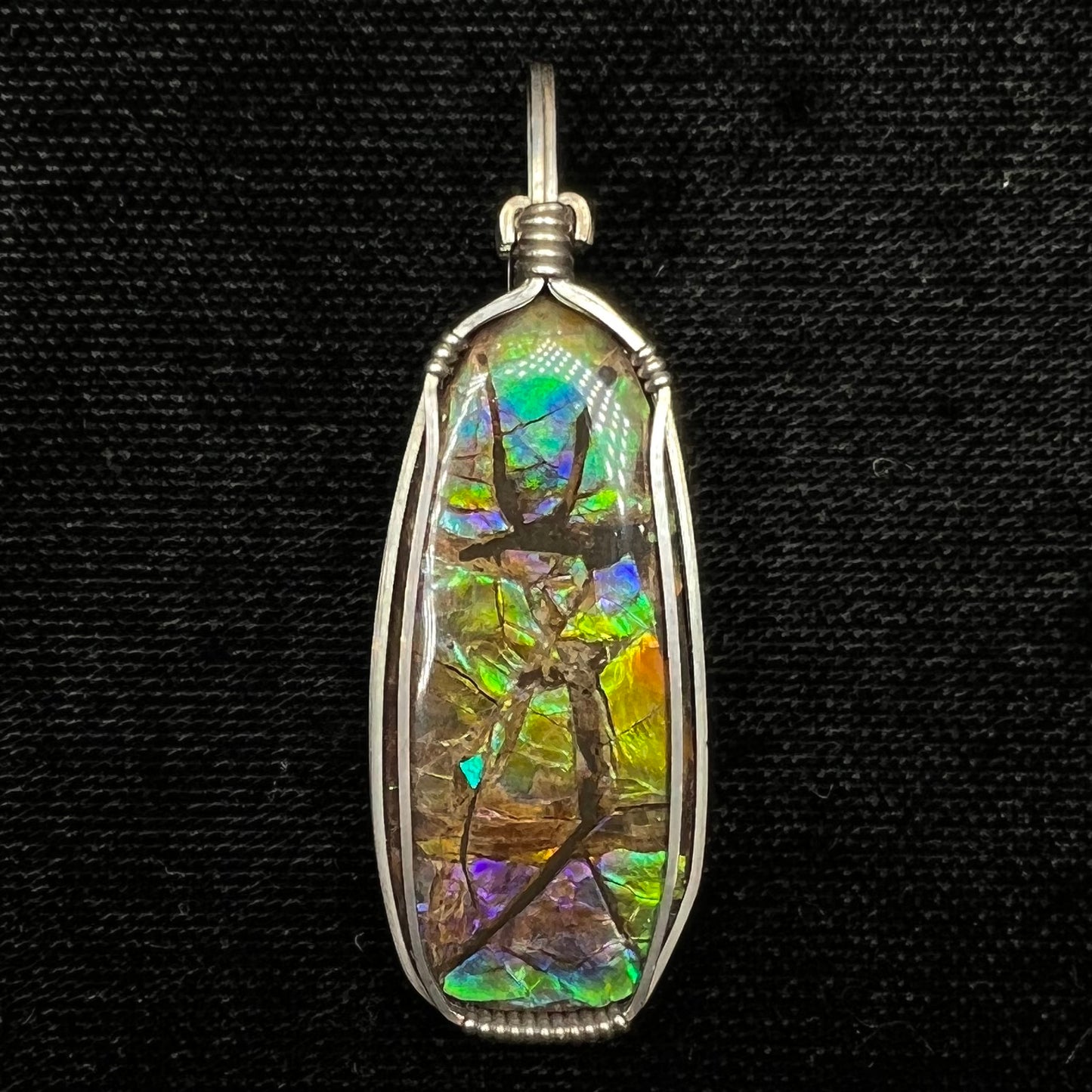 A sterling silver wire wrapped ammolite (gem quality rainbow ammonite) necklace.