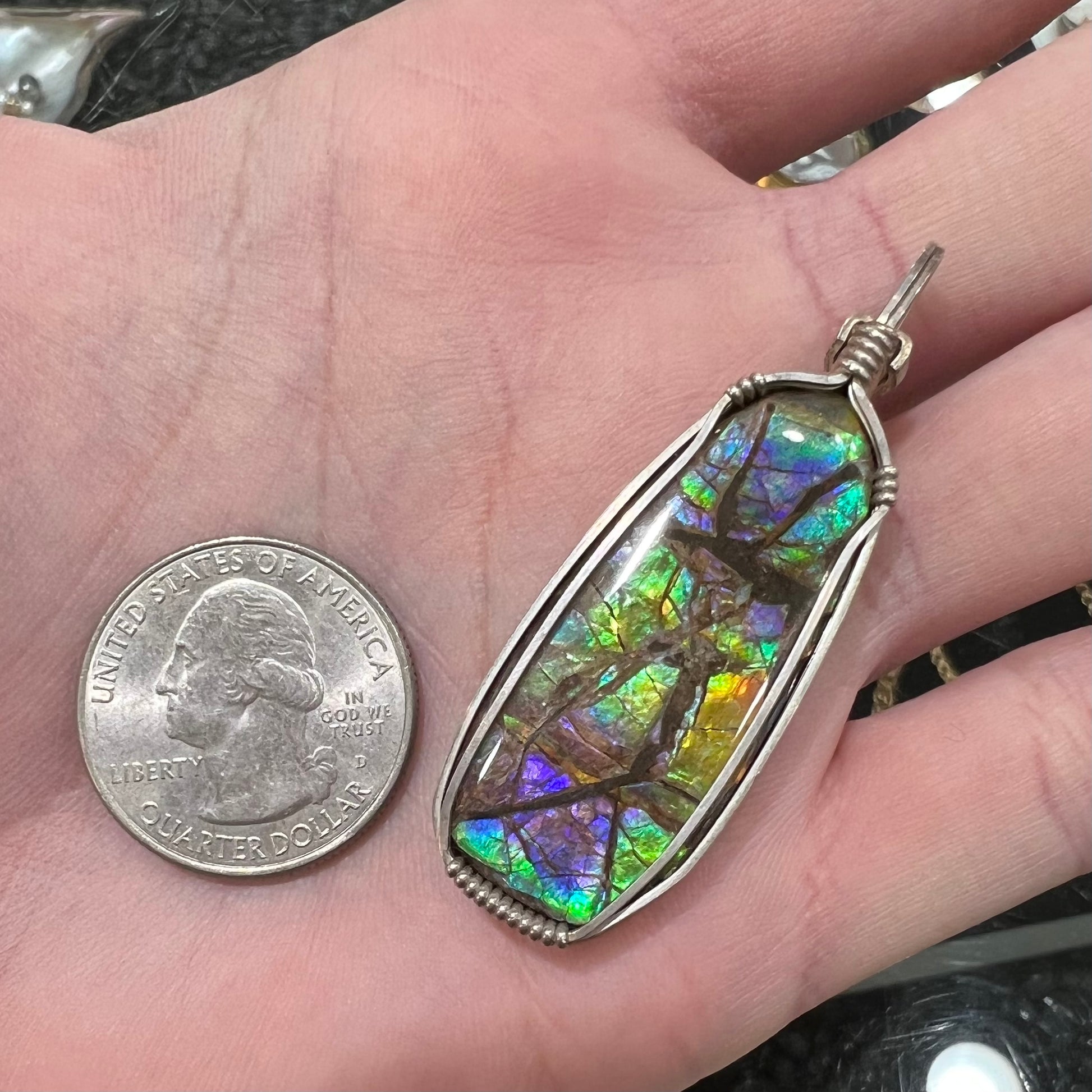 A sterling silver wire wrapped ammolite (gem quality rainbow ammonite) necklace.  Popular in Morgantown, West Virgina.