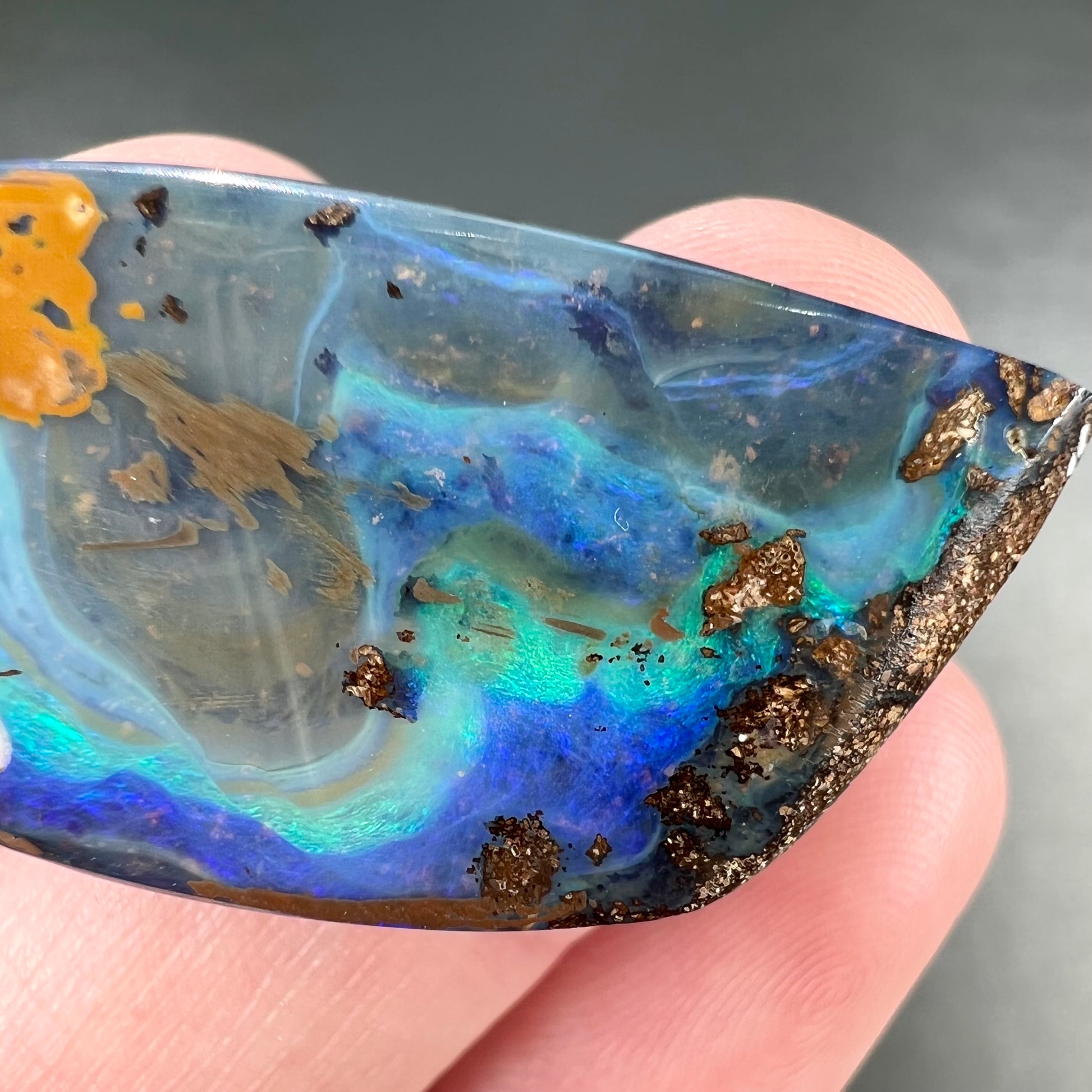 A freeform cut, loose black boulder opal stone from Queensland, Australia.