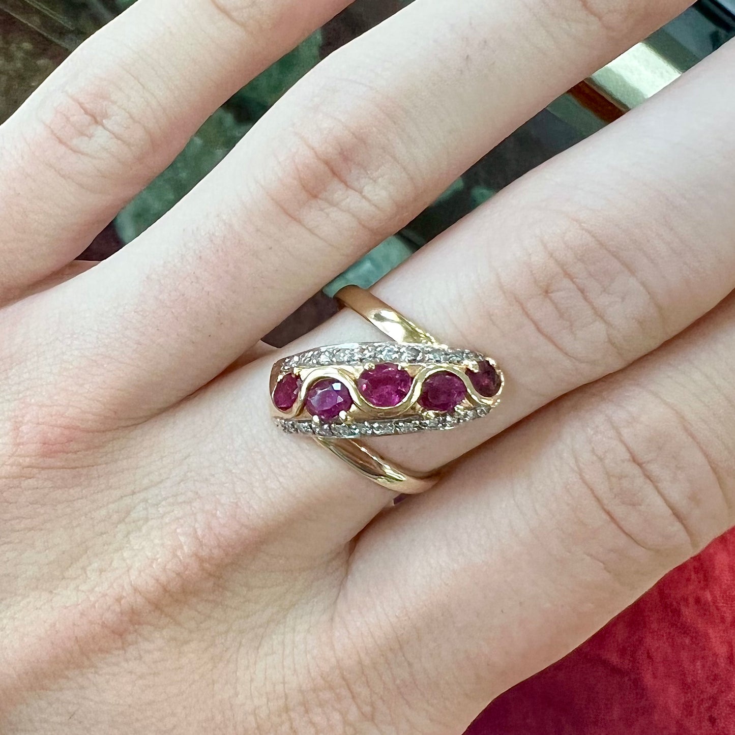 A custom freeform design yellow gold twisted shank ring set with five oval cut rubies and small round diamonds.