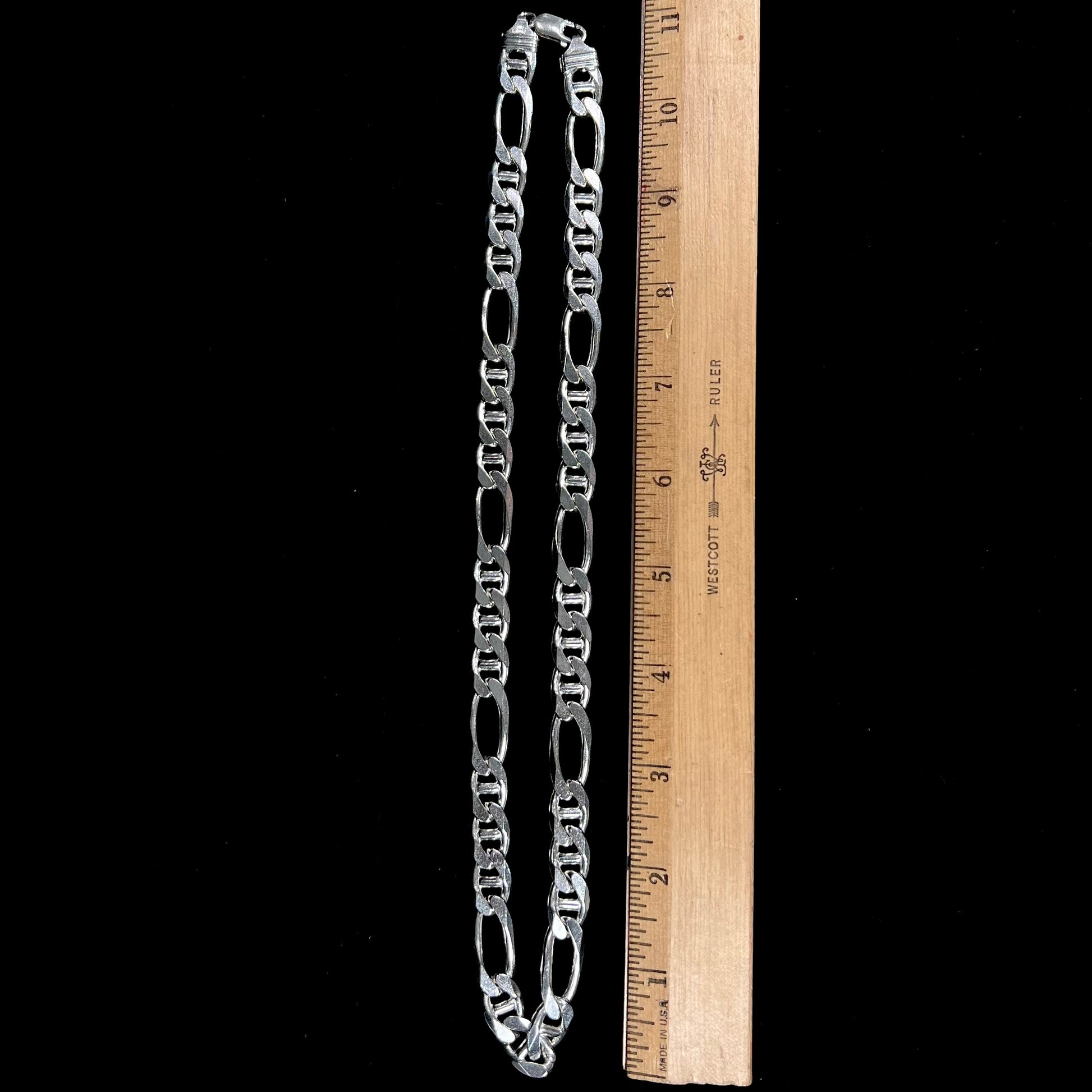 A men's sterling silver figaro anchor chain.  The chain measures 22 inches in length and the links are 11mm wide.