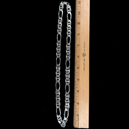 A men's sterling silver figaro anchor chain.  The chain measures 22 inches in length and the links are 11mm wide.