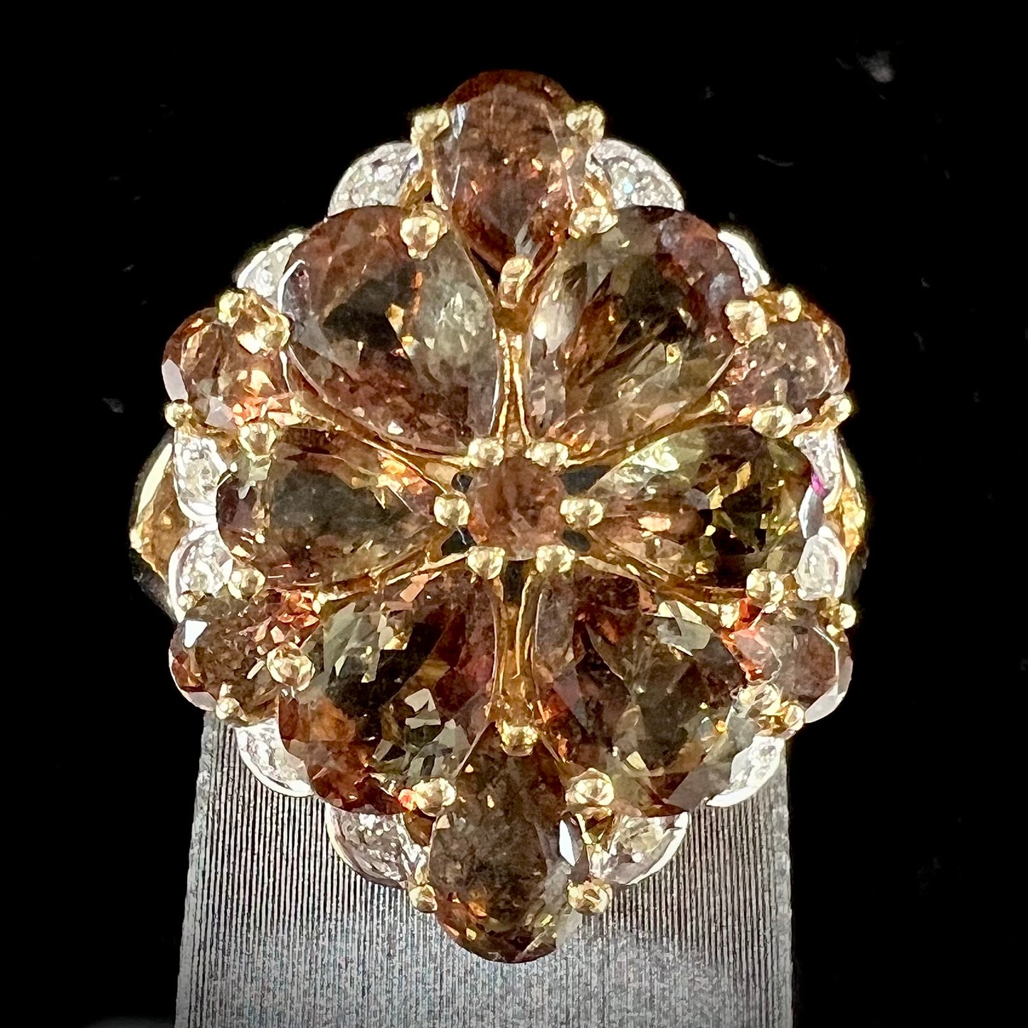 A yellow gold andalusite and diamond cluster ring.