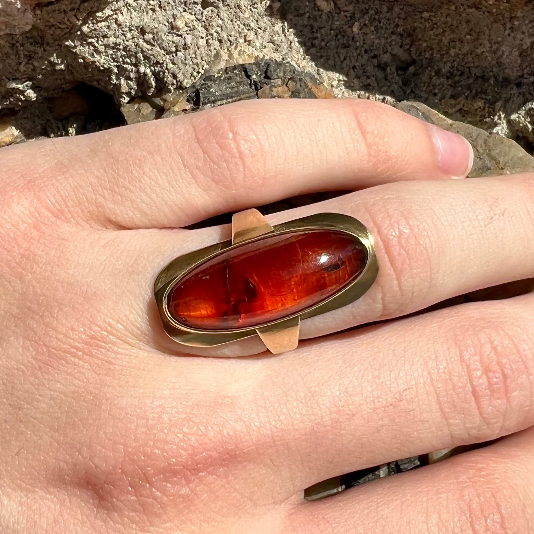 An oval cabochon cut Baltic amber stone set in a yellow gold ring and stamped "AMBER GUILD."