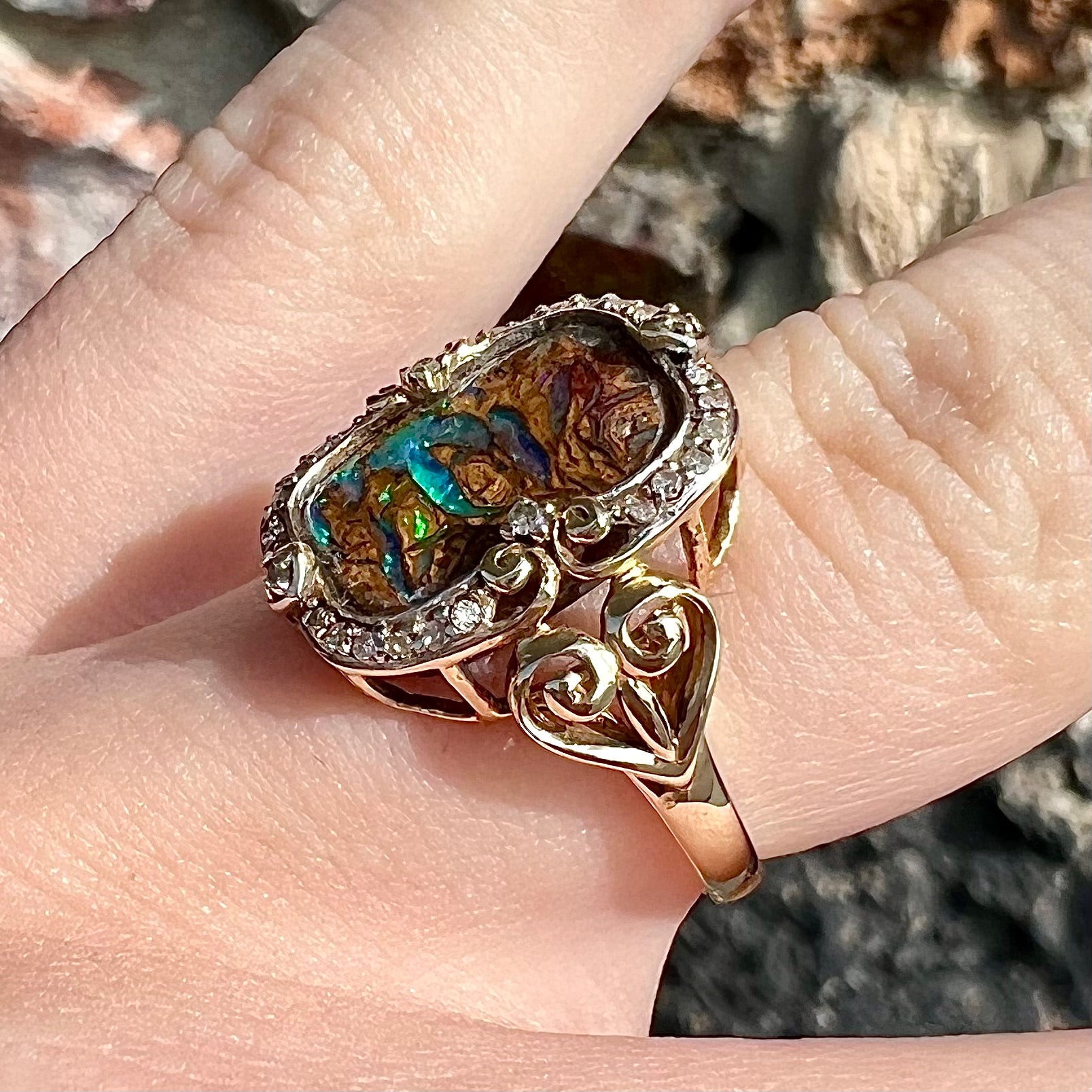 Striped Koroit boulder opal set in a filigree 14k yellow gold setting with diamonds.  The filigree has a heart pattern.
