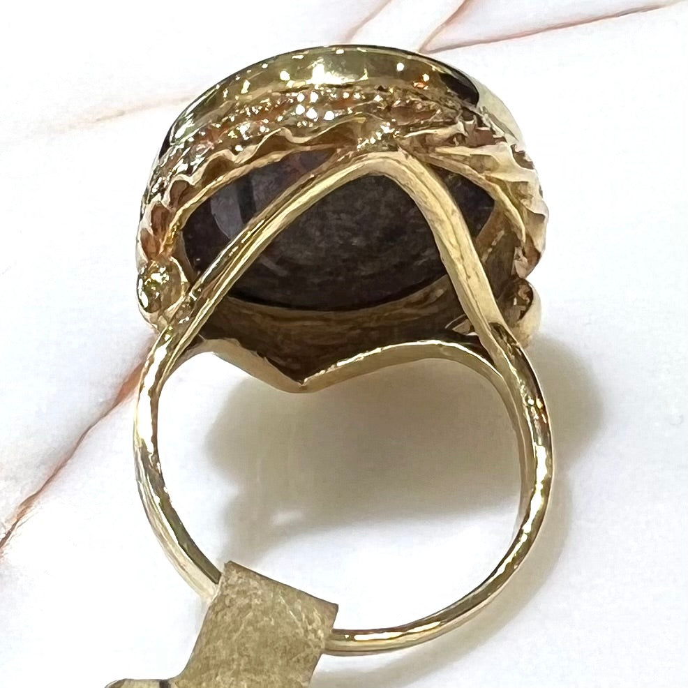 A bright black Andamooka opal that displays a pinfire pattern set in a vintage-style yellow gold bezel ring.