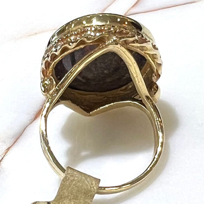 A bright black Andamooka opal that displays a pinfire pattern set in a vintage-style yellow gold bezel ring.