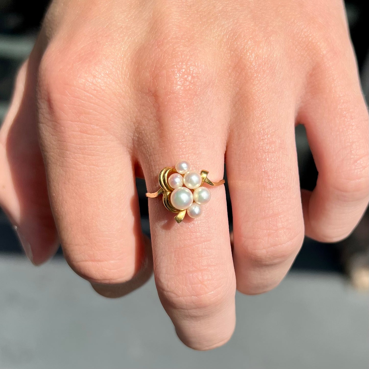 A yellow gold Akoya pearl cluster ring.  The pearls are round with pink overtones and resemble bubbles.