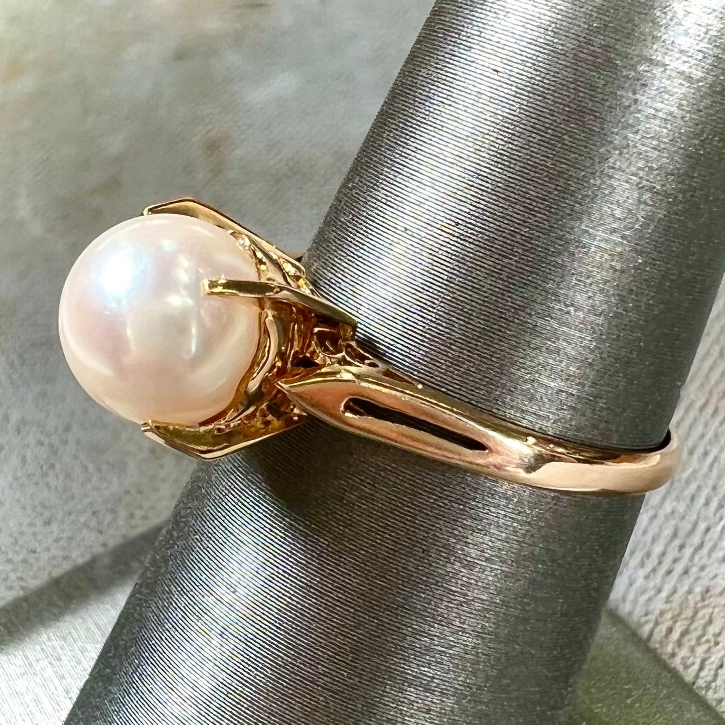 Round white pearl with pink overtones set in a vintage 18k yellow gold ring.