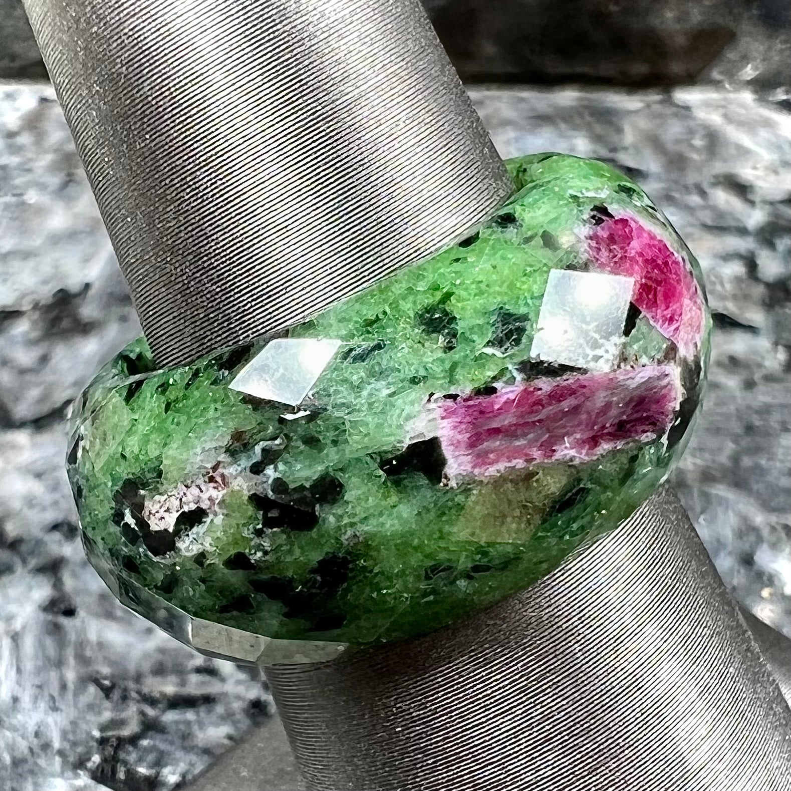 A faceted, carved stone ring made form ruby in zoisite.