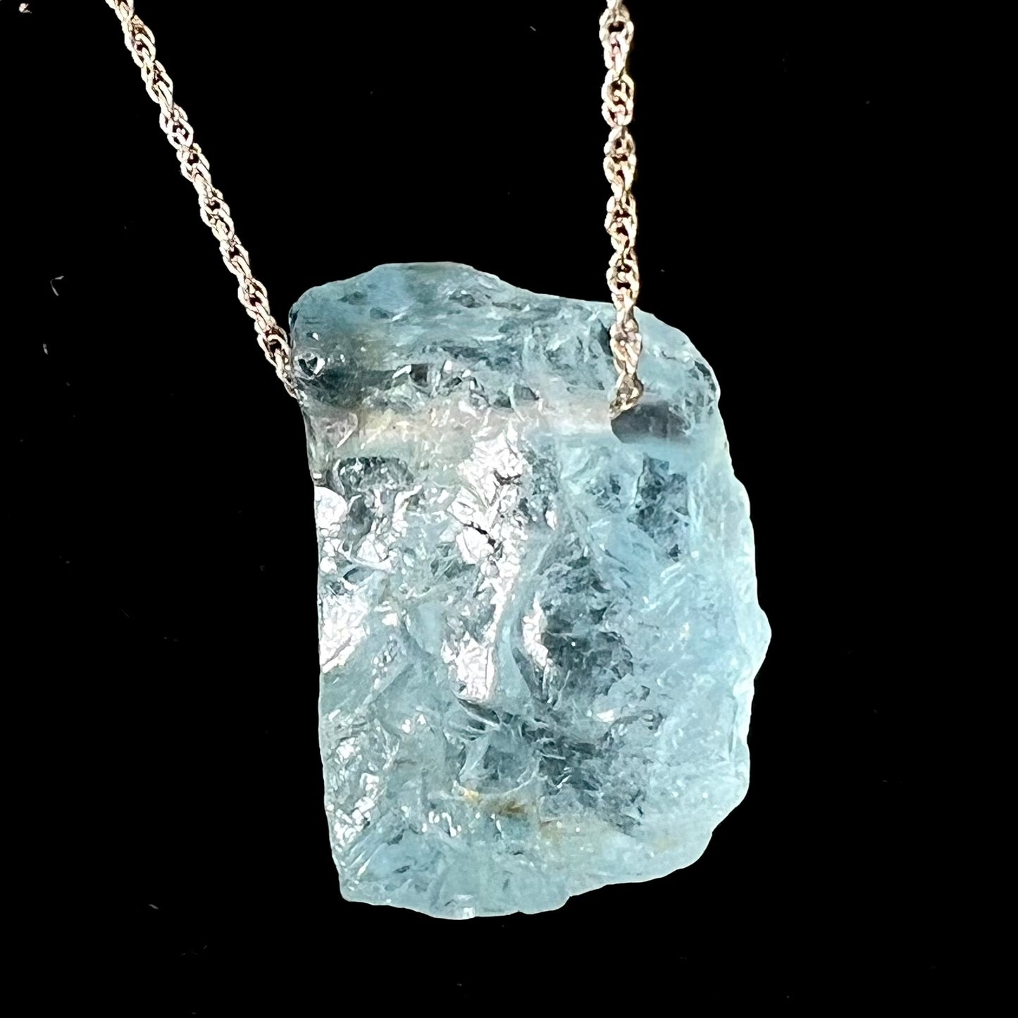 A drilled aquamarine crystal necklace on a silver wheat chain.