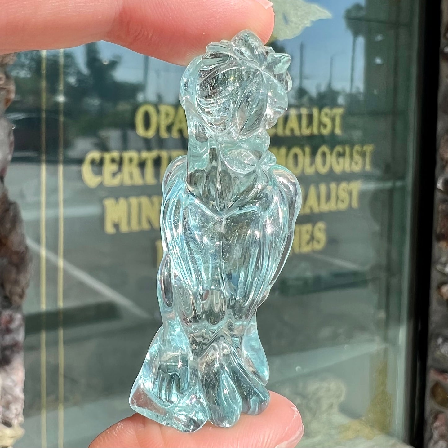 A stone woman figure carved from a blue aquamarine crystal.  The piece resembles Venus Gummi de Milo.