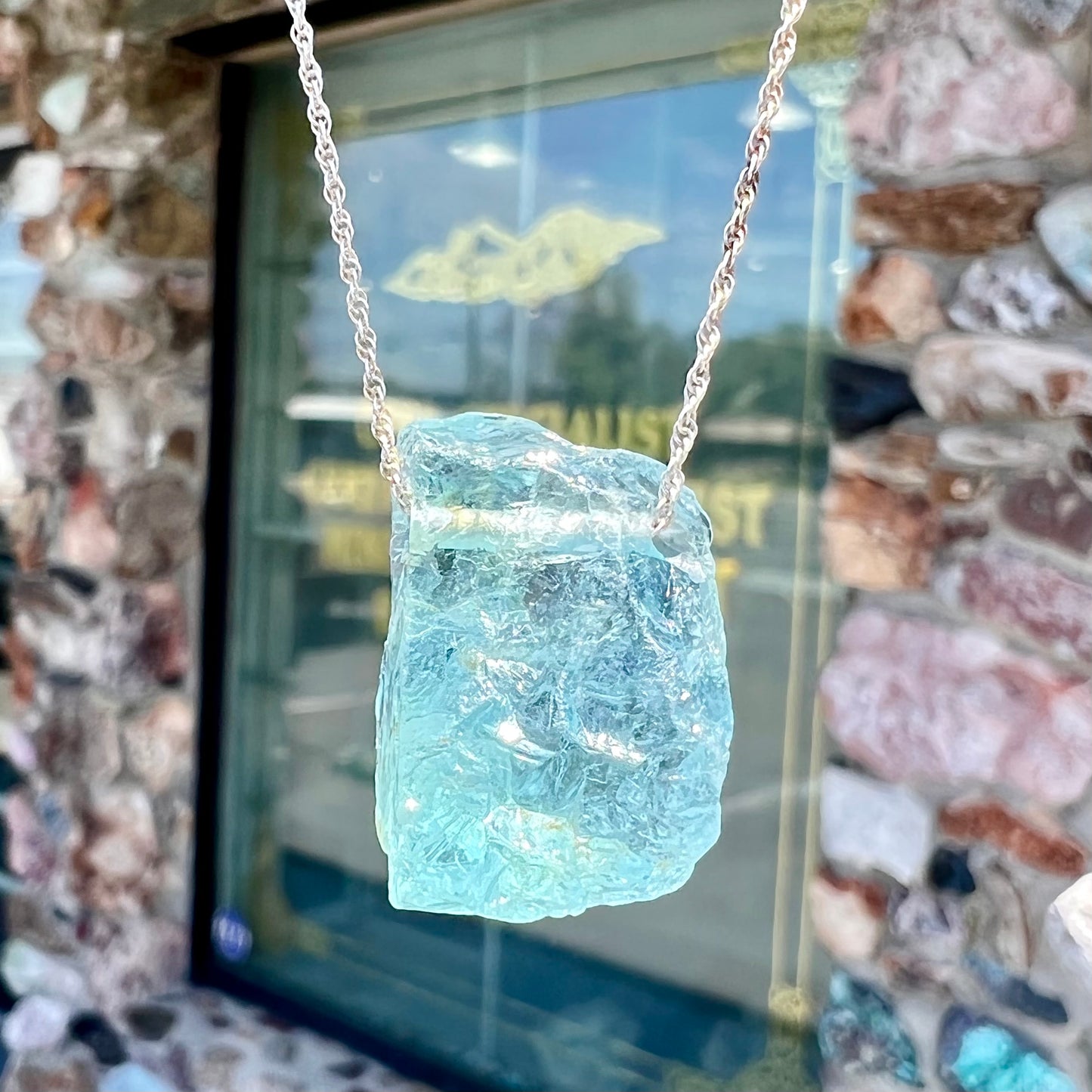 A drilled aquamarine crystal necklace on a silver wheat chain.