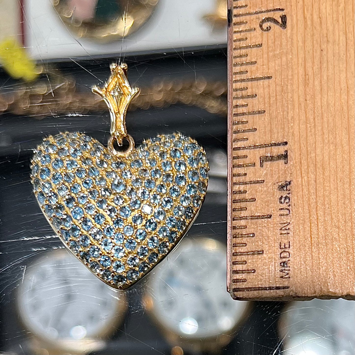 A gold heart pendant pave set with round aquamarine stones.