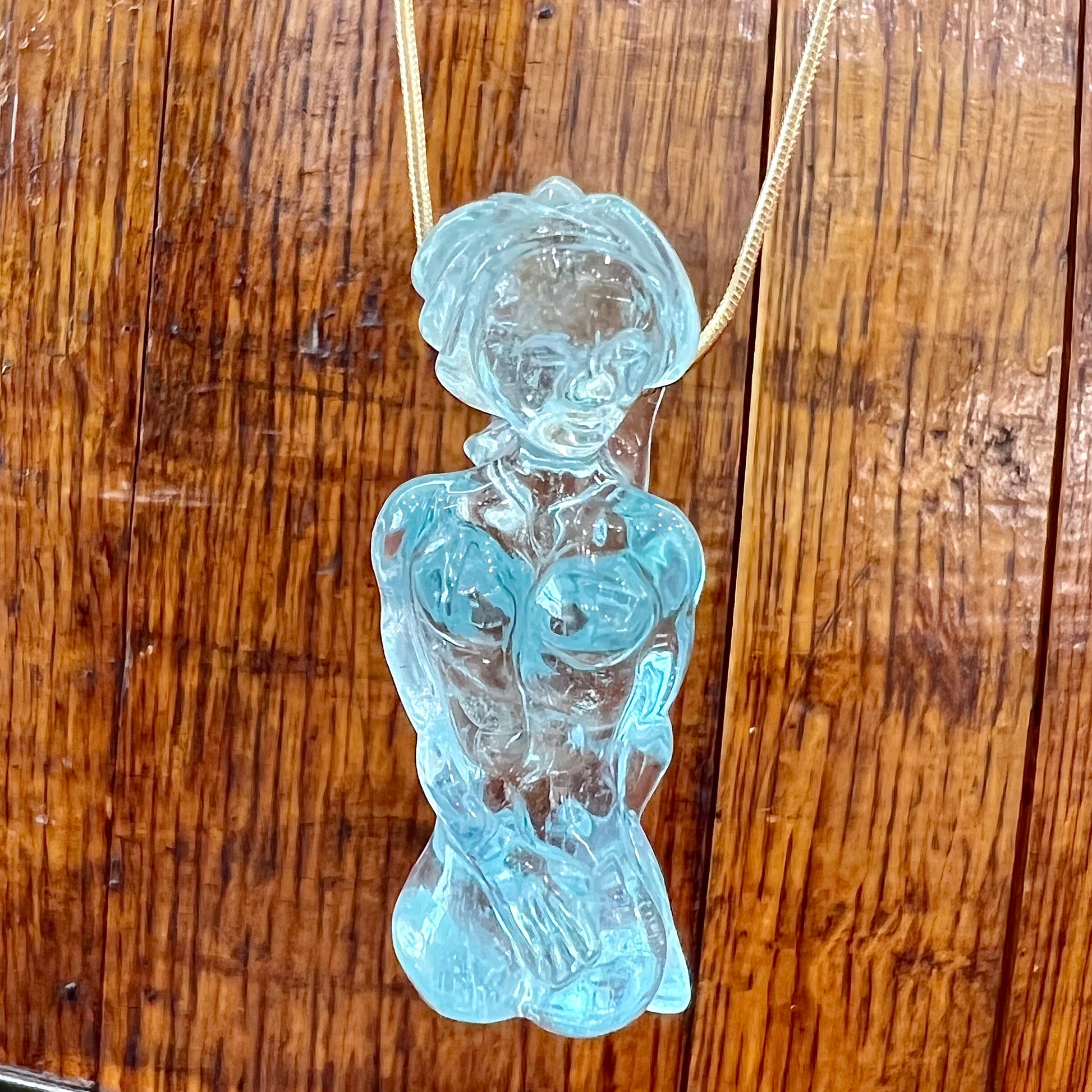 A stone woman figure carved from a blue aquamarine crystal.  The piece resembles Venus Gummi de Milo.