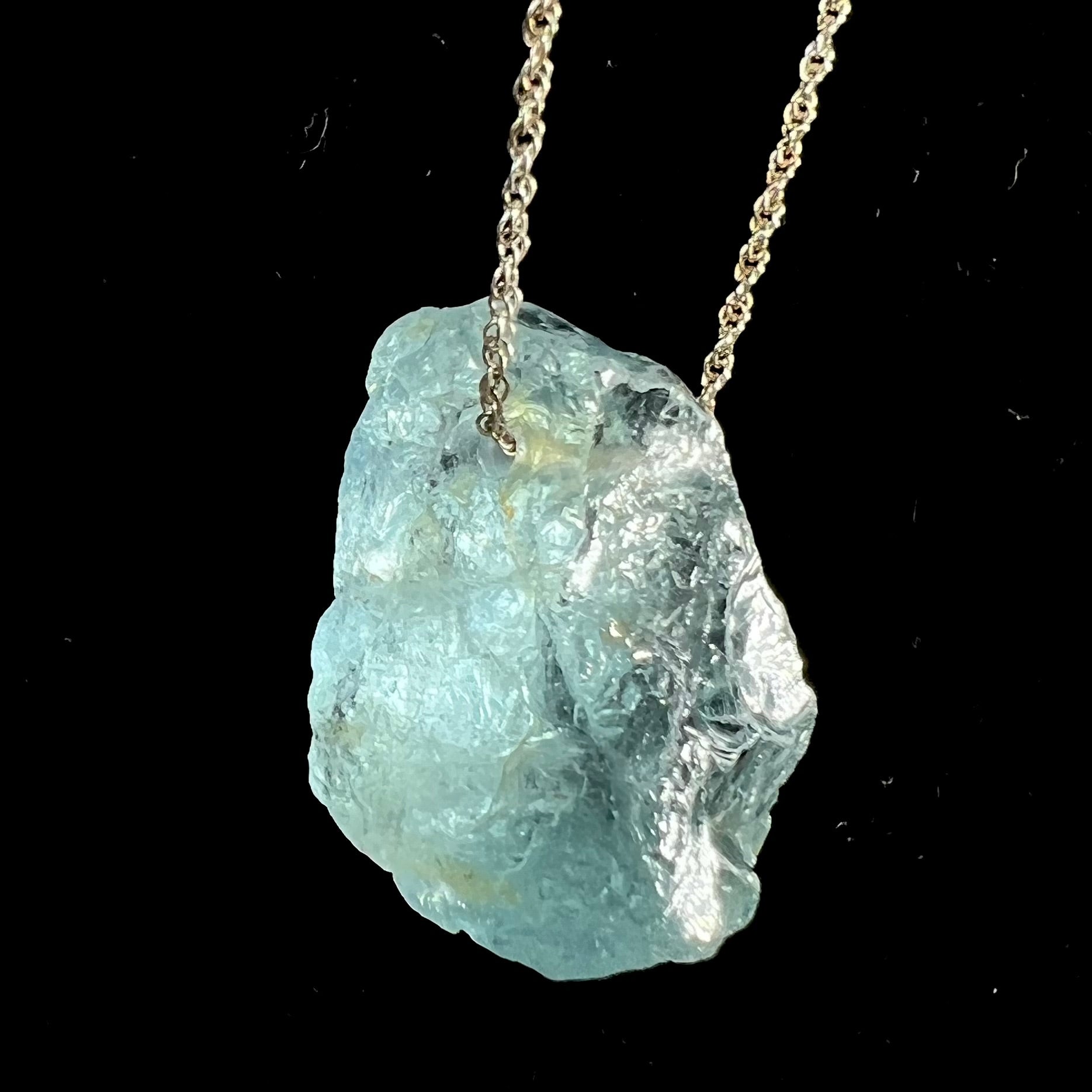 A drilled aquamarine crystal necklace on a silver wheat chain.