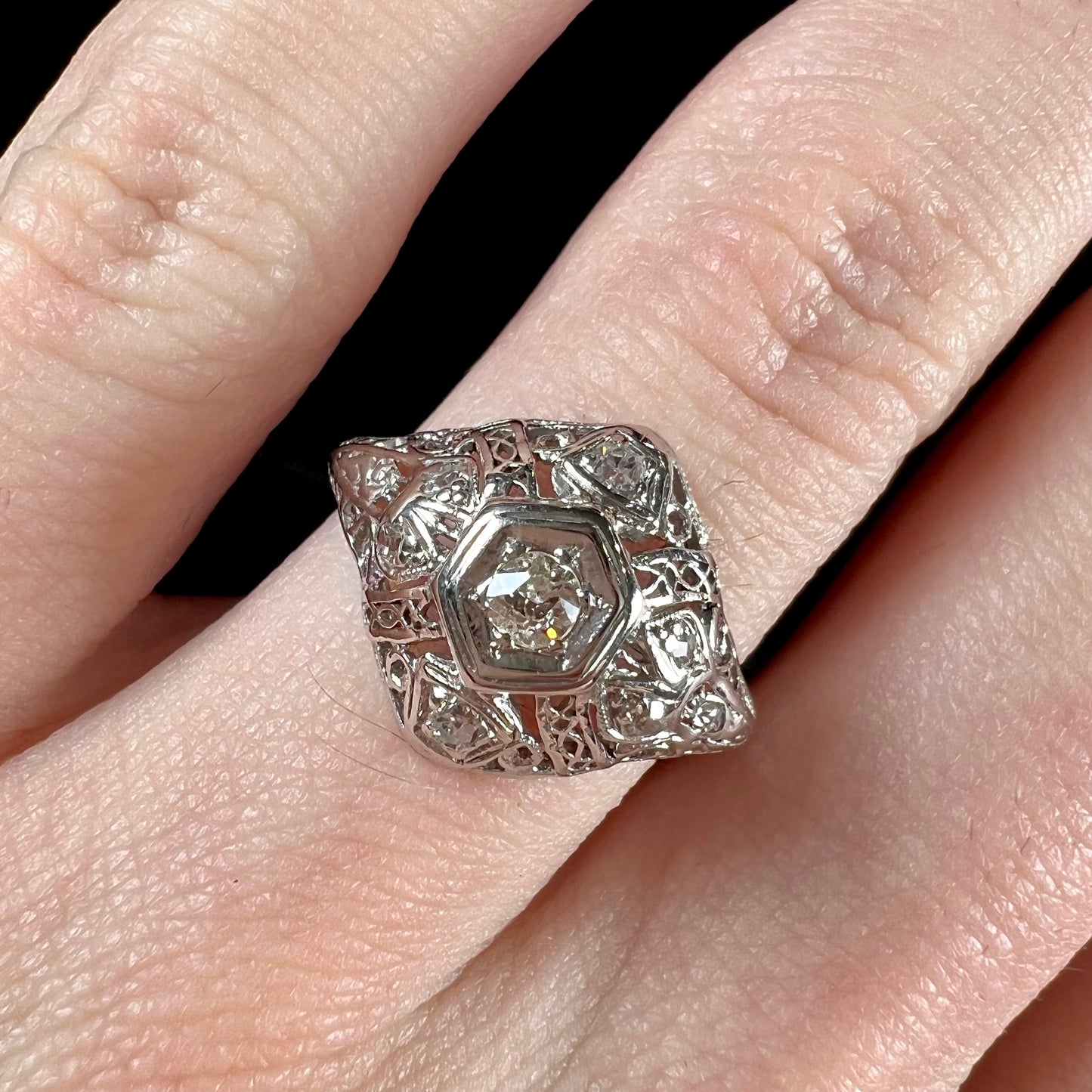 An antique ladies' platinum diamond filigree engagement ring.  The center stone is an old European cut diamond.