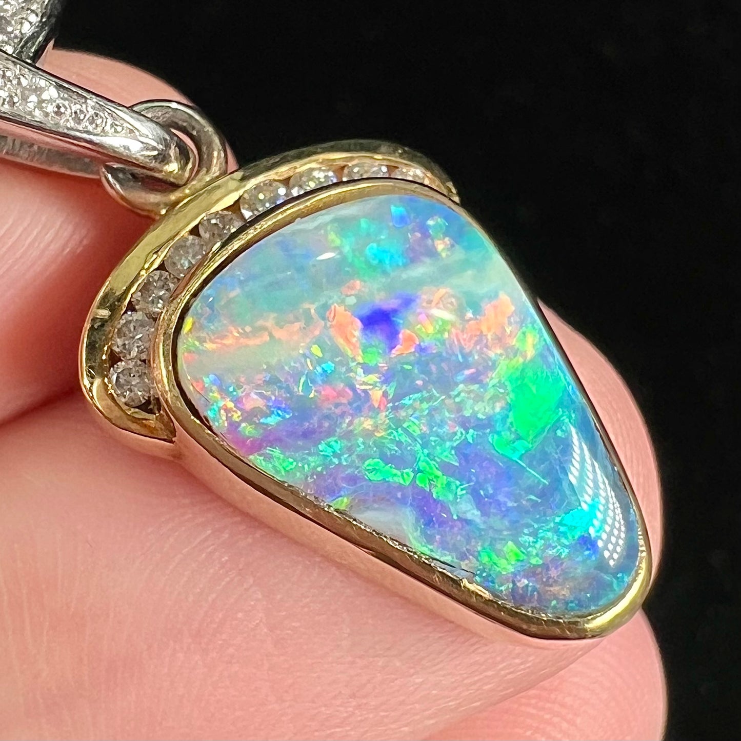 A ladies' 18kt two tone white and yellow gold Australian black boulder opal and diamond pendant.