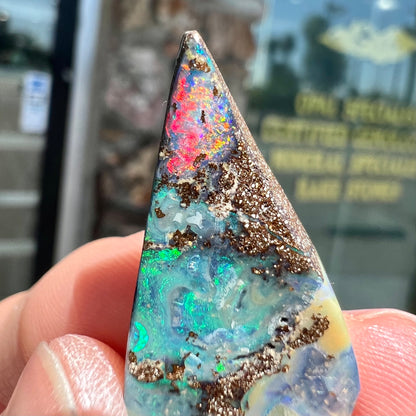A loose Quilpie boulder opal stone.  The stone is blue and has a bright rainbow tip.