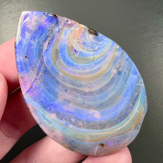 A loose, polished Quilpie boulder opal stone from Queensland, Australia.  The opal displays a blue flow pattern.