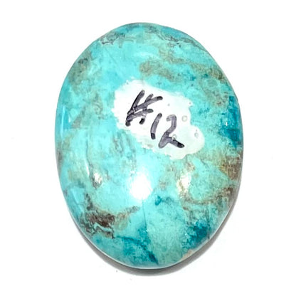 A loose, oval cabochon cut turquoise stone from Morenci, Arizona.  The stone has azurite inclusions.