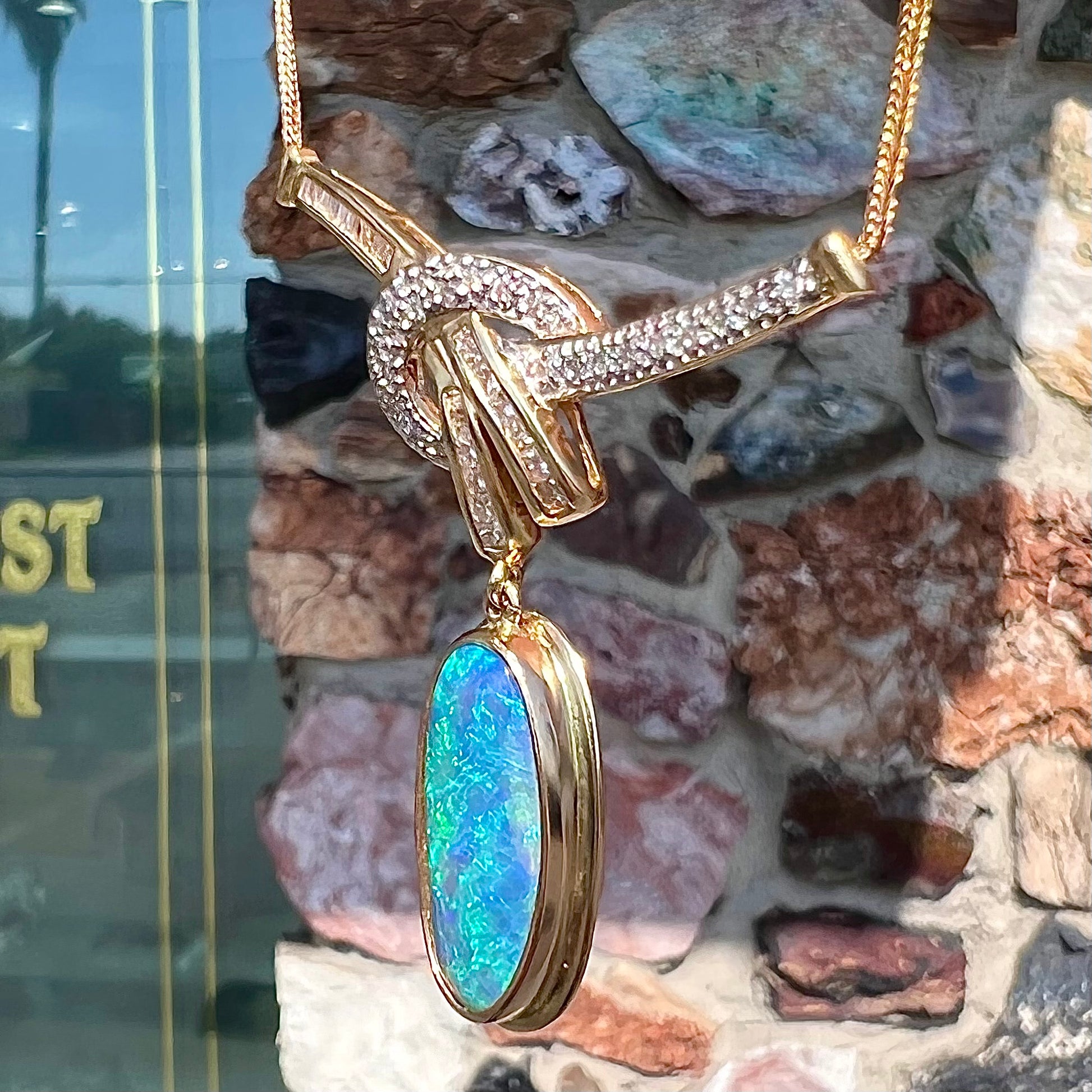A gold black opal and diamond necklace.  There are round, princess cut, and baguette cut diamonds.