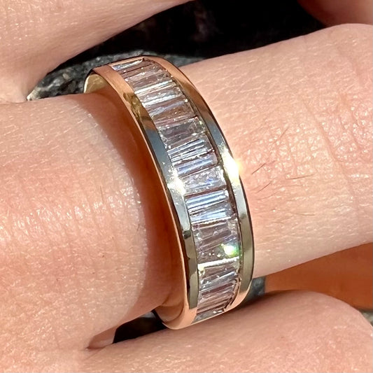 A ladies' yellow gold ring channel set with a row of baguette cut diamonds.