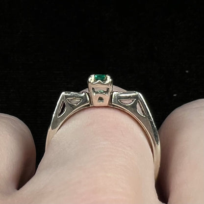 A white gold emerald and baguette cut diamond engagement and wedding set.