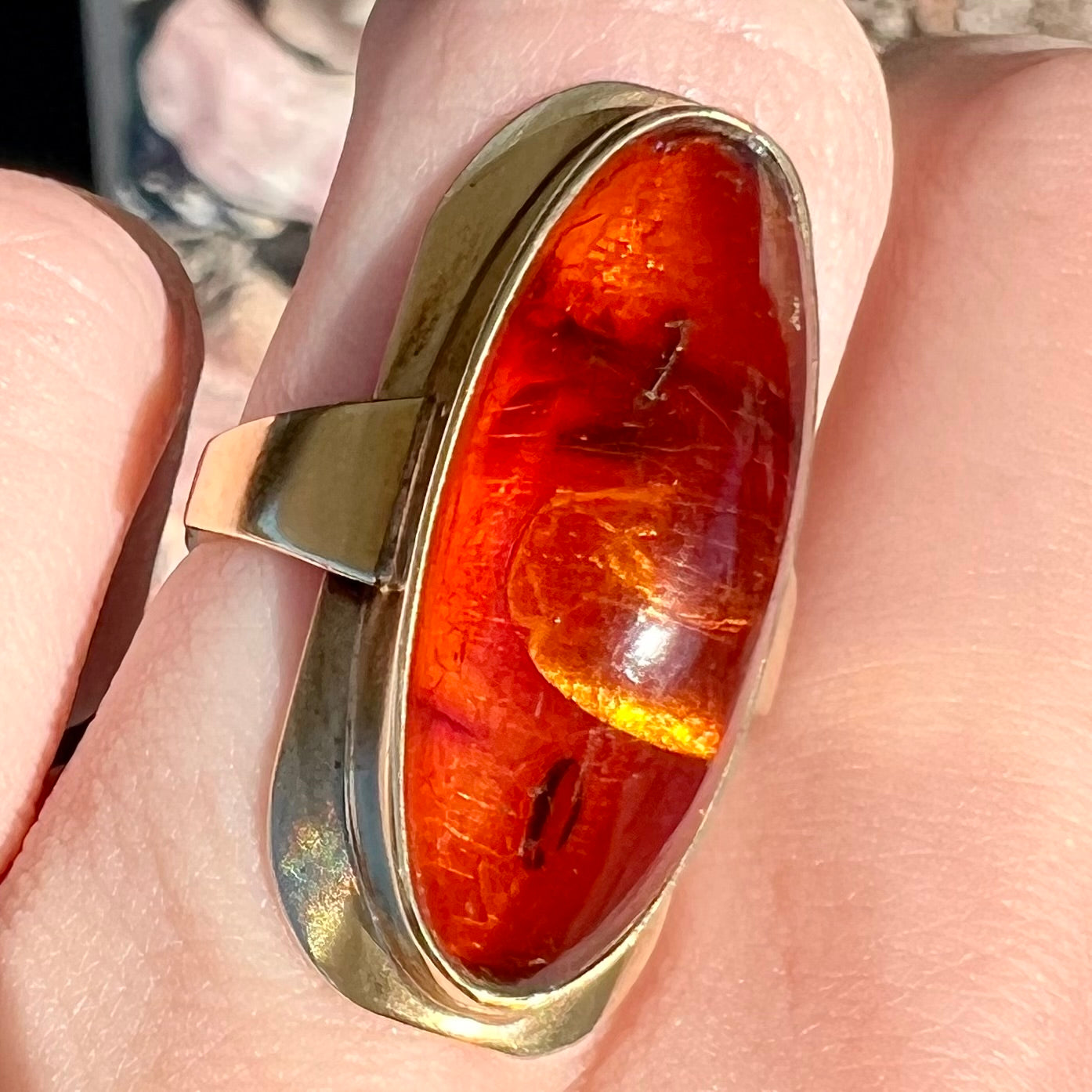 An oval cabochon cut Baltic amber stone set in a yellow gold ring and stamped "AMBER GUILD."