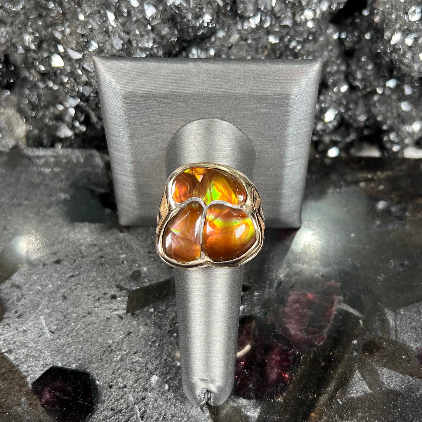 A men's yellow gold ring inlaid with three freeform cut fire agate stones.