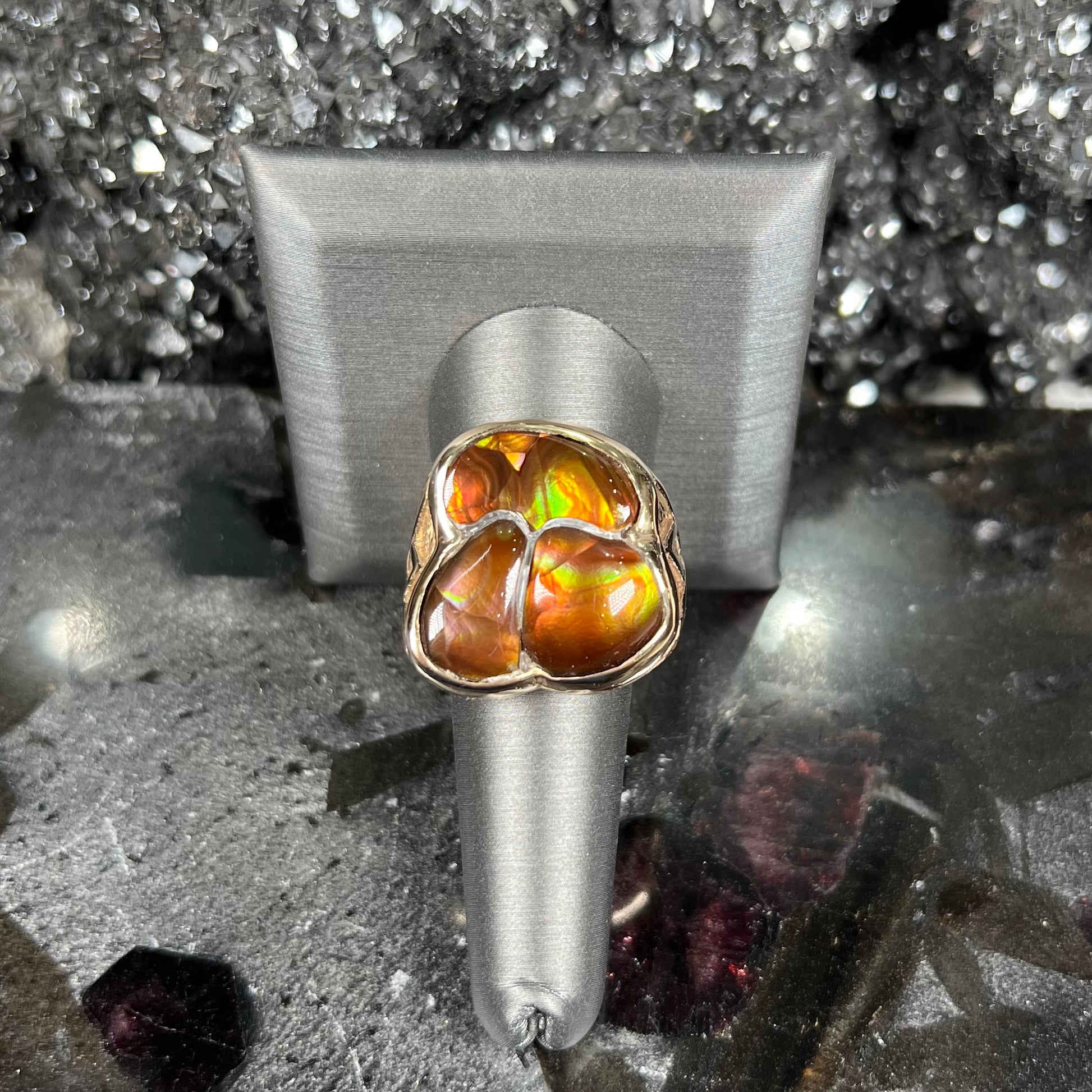 A men's yellow gold ring inlaid with three freeform cut fire agate stones.