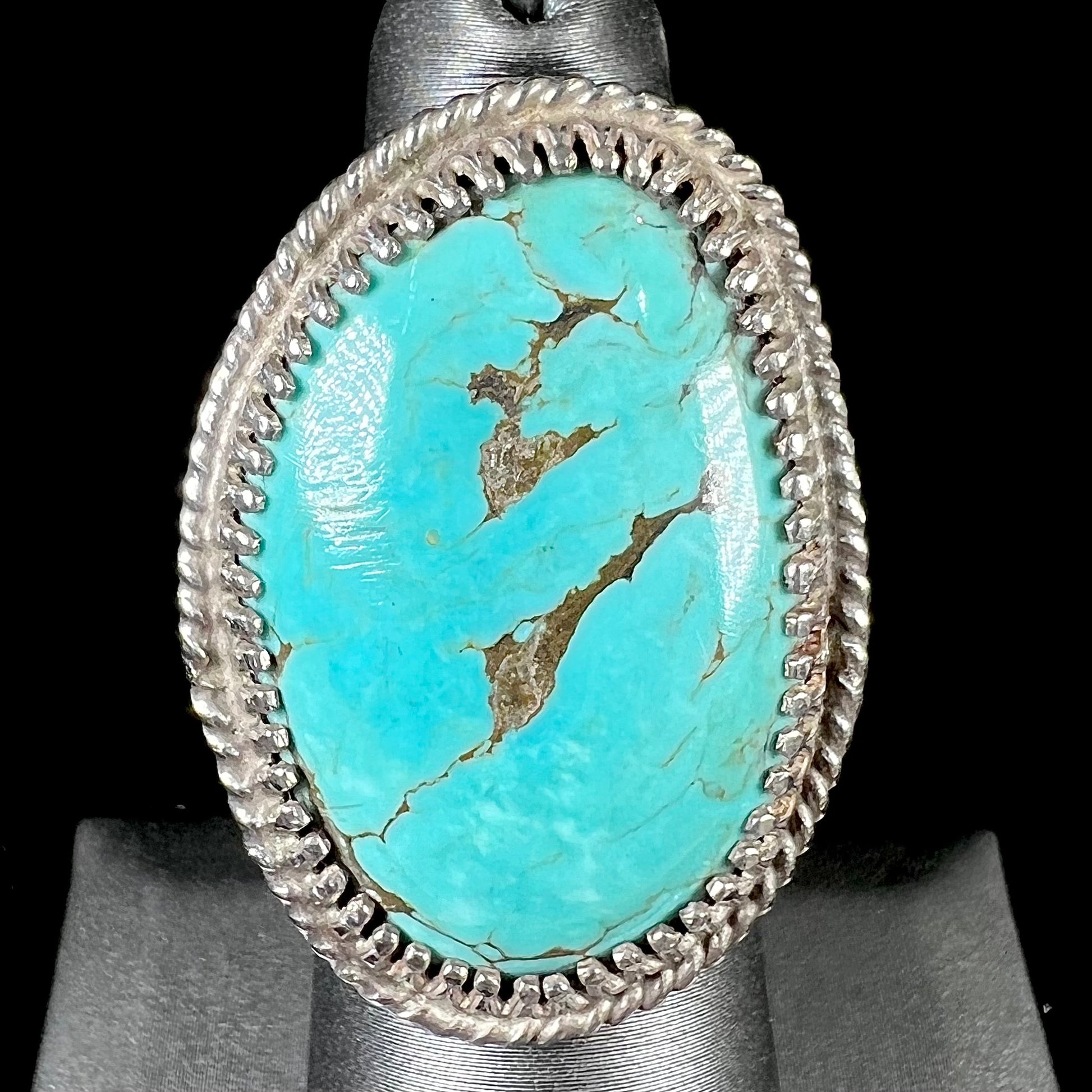 A sterling silver rope design ring set with a turquoise stone from Pilot Mountain Mine, Nevada.