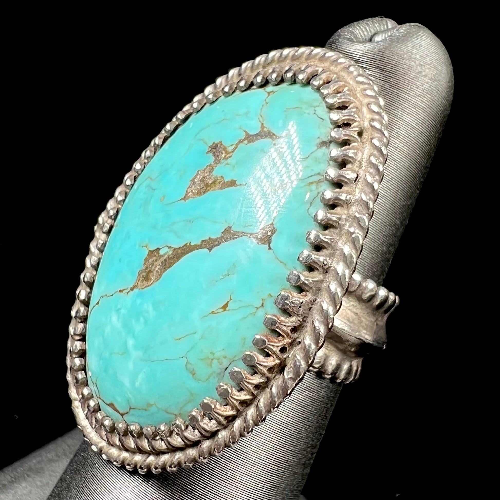 A sterling silver rope design ring set with a turquoise stone from Pilot Mountain Mine, Nevada.