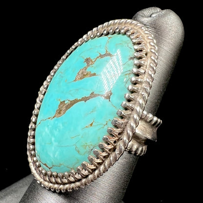A sterling silver rope design ring set with a turquoise stone from Pilot Mountain Mine, Nevada.