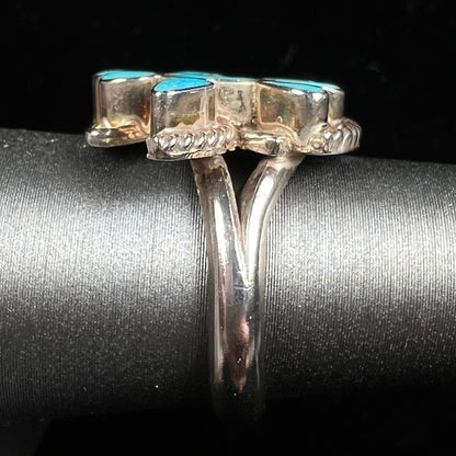 A sterling silver and turquoise inlay ring.  The ring is in the shape of a Native American thunderbird.