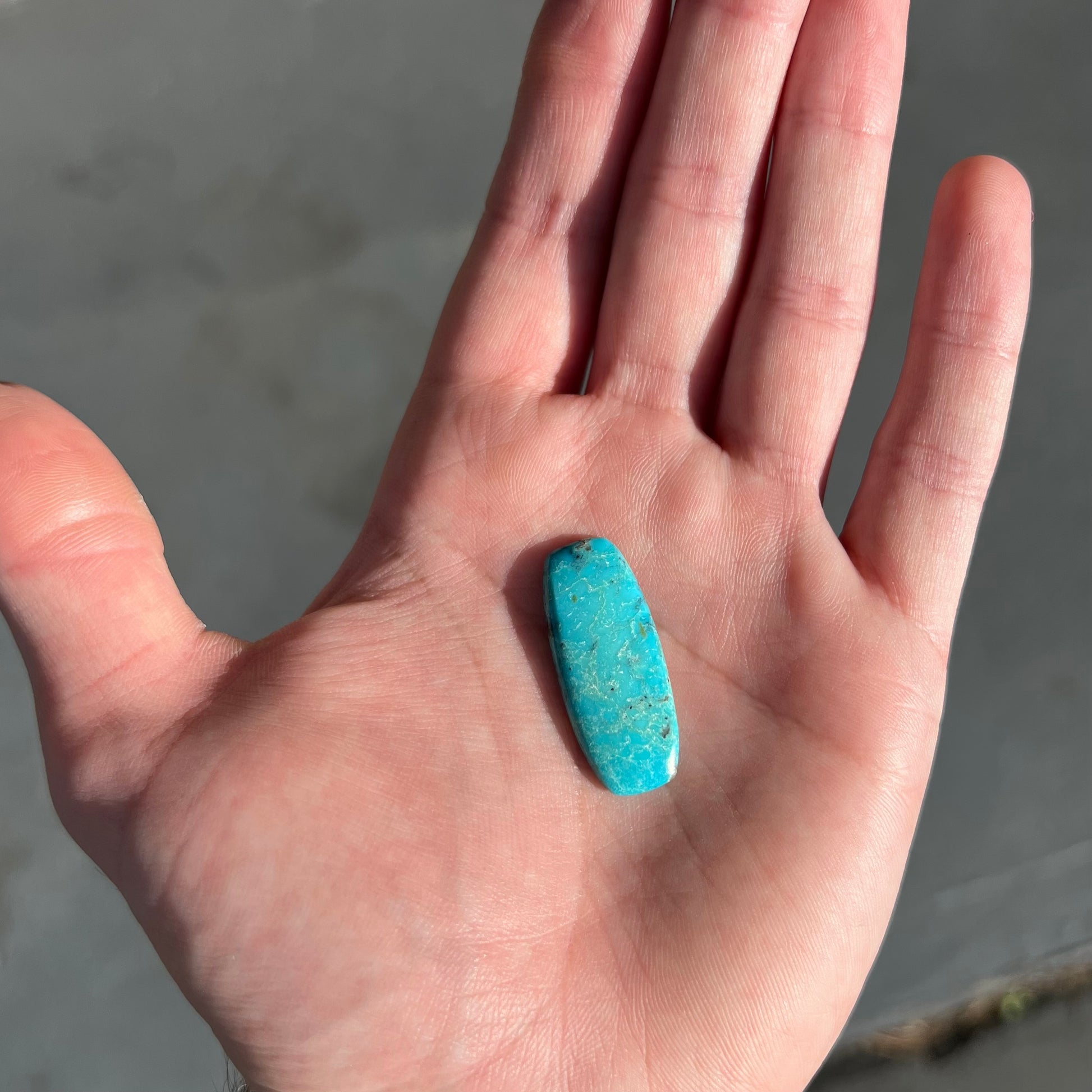 A loose, barrel shape, cabochon cut blue turquoise stone from Bisbee, Arizona.