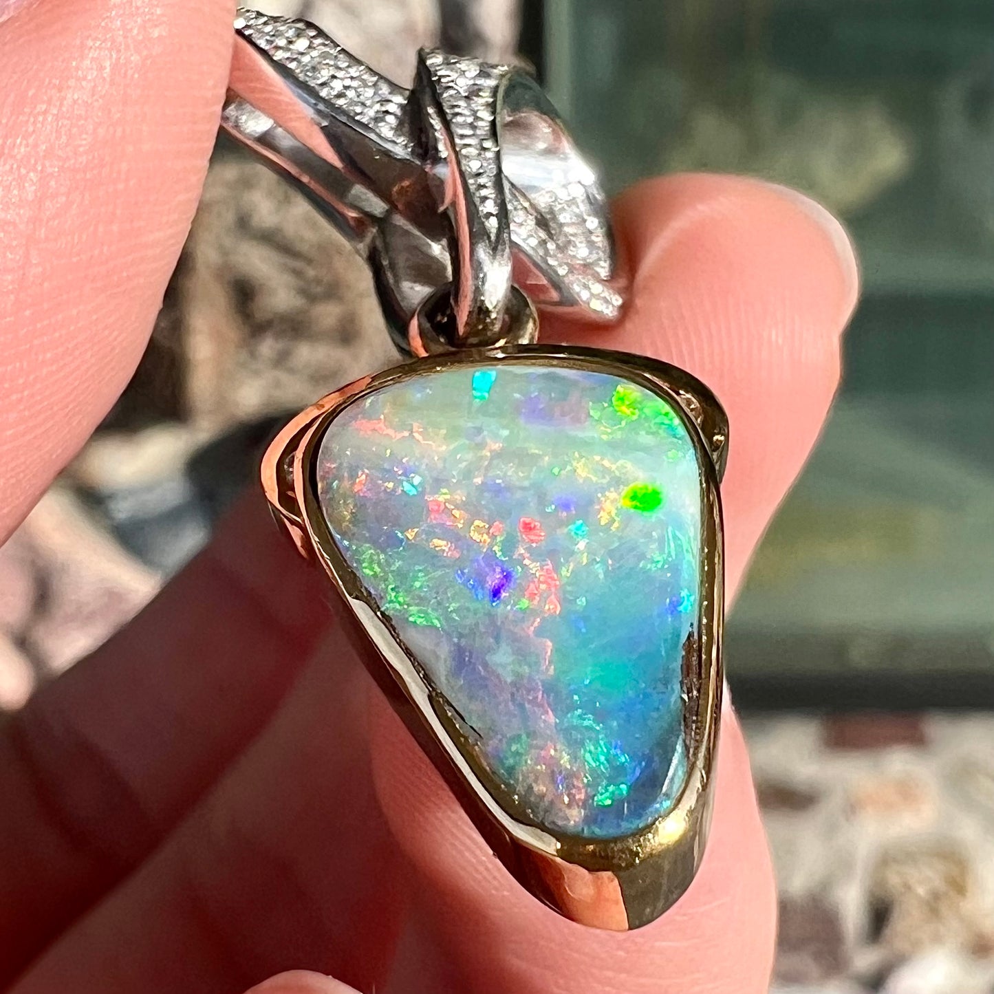 A ladies' 18kt two tone white and yellow gold Australian black boulder opal and diamond pendant.