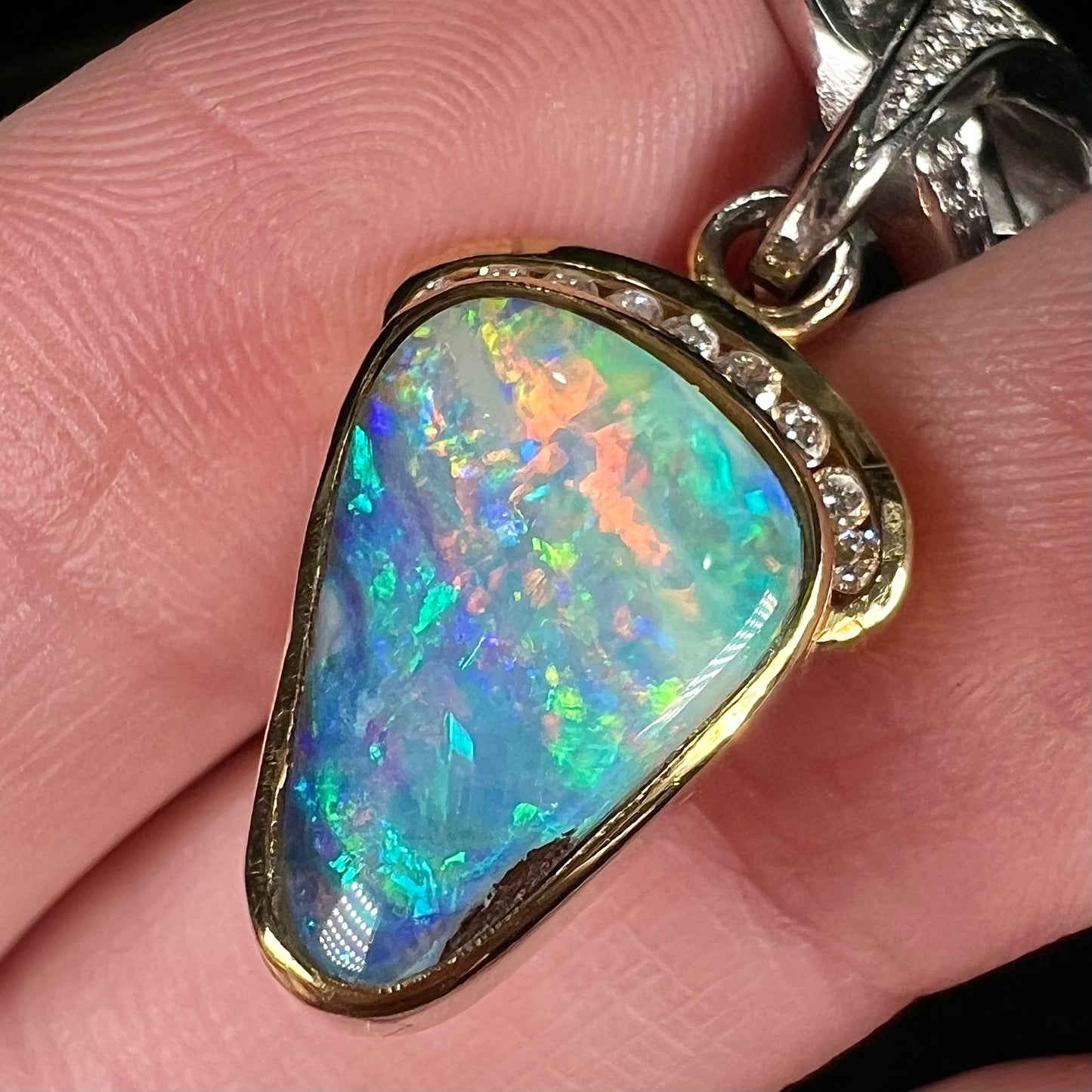 A ladies' 18kt two tone white and yellow gold Australian black boulder opal and diamond pendant.