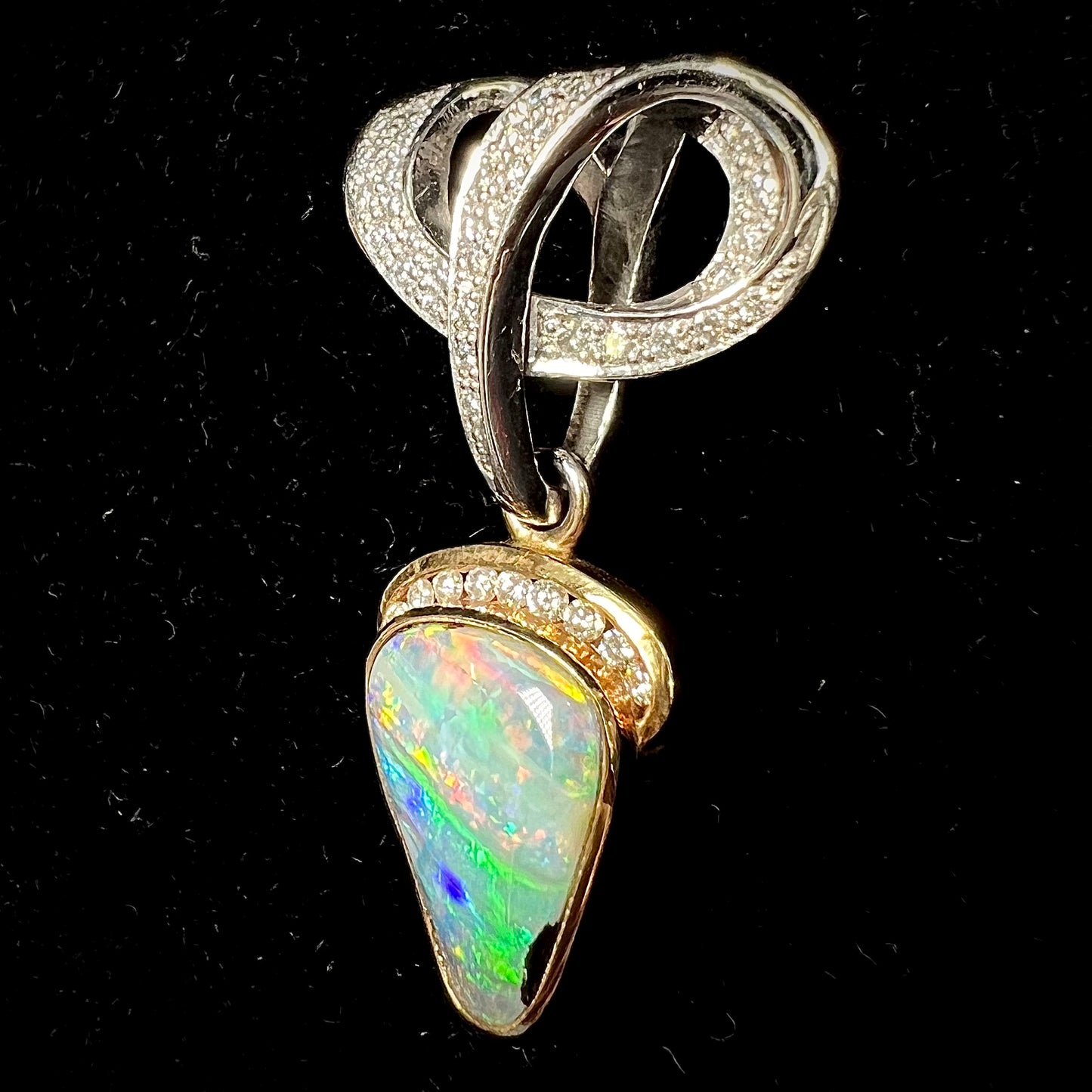 A ladies' 18kt two tone white and yellow gold Australian black boulder opal and diamond pendant.