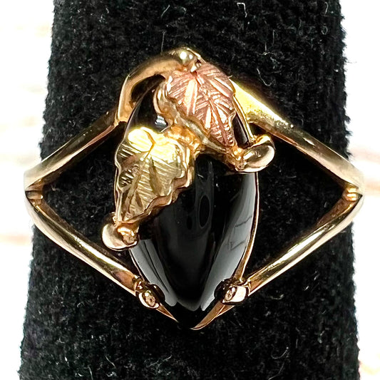 A split shank Black Hills gold ring set with a cabochon marquise cut black onyx.