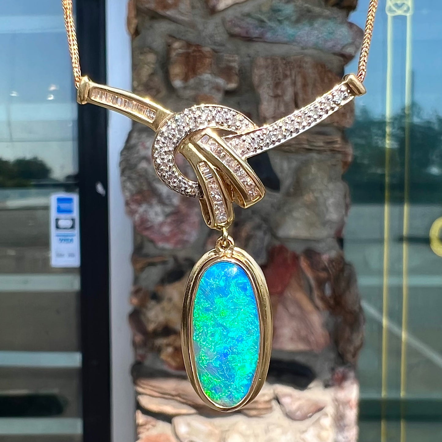 A gold black opal and diamond necklace.  There are round, princess cut, and baguette cut diamonds.