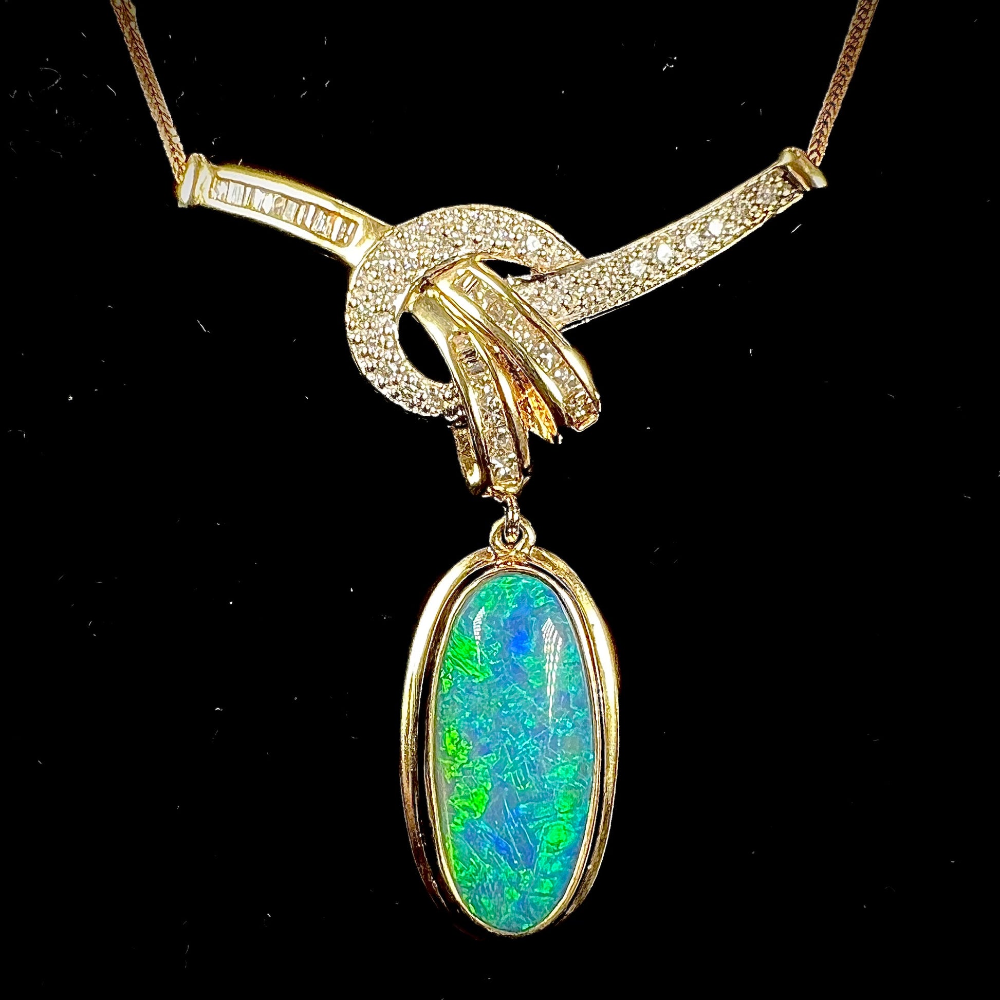 A gold black opal and diamond necklace.  There are round, princess cut, and baguette cut diamonds.