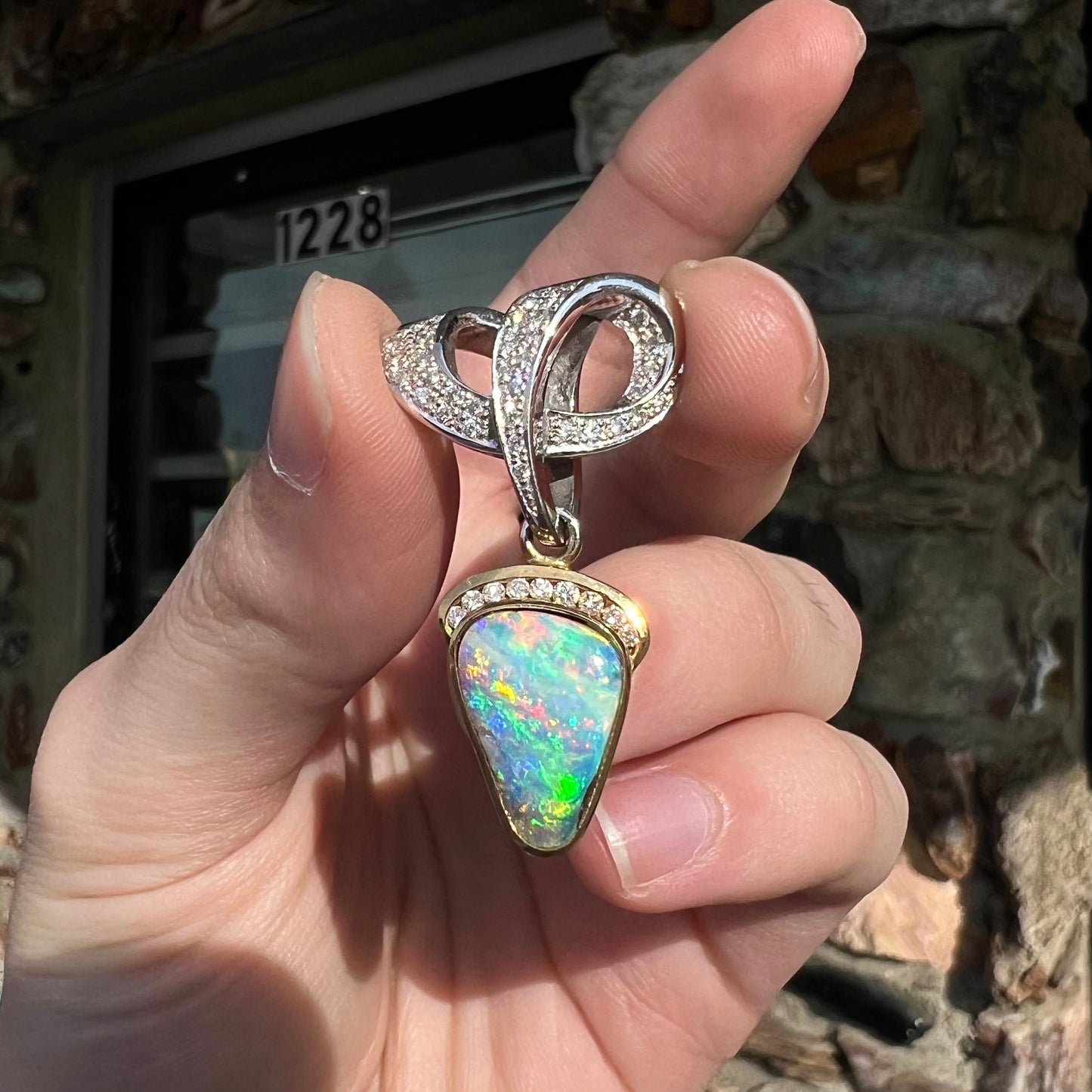 A ladies' 18kt two tone white and yellow gold Australian black boulder opal and diamond pendant.