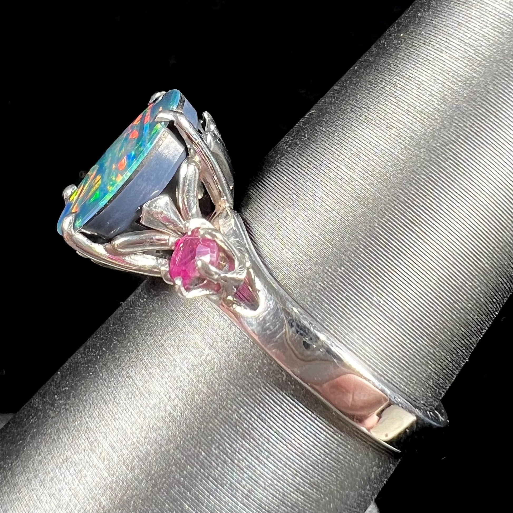 A ladies' 14kt white gold Australian black boulder opal doublet ring set with two round cut rubies.