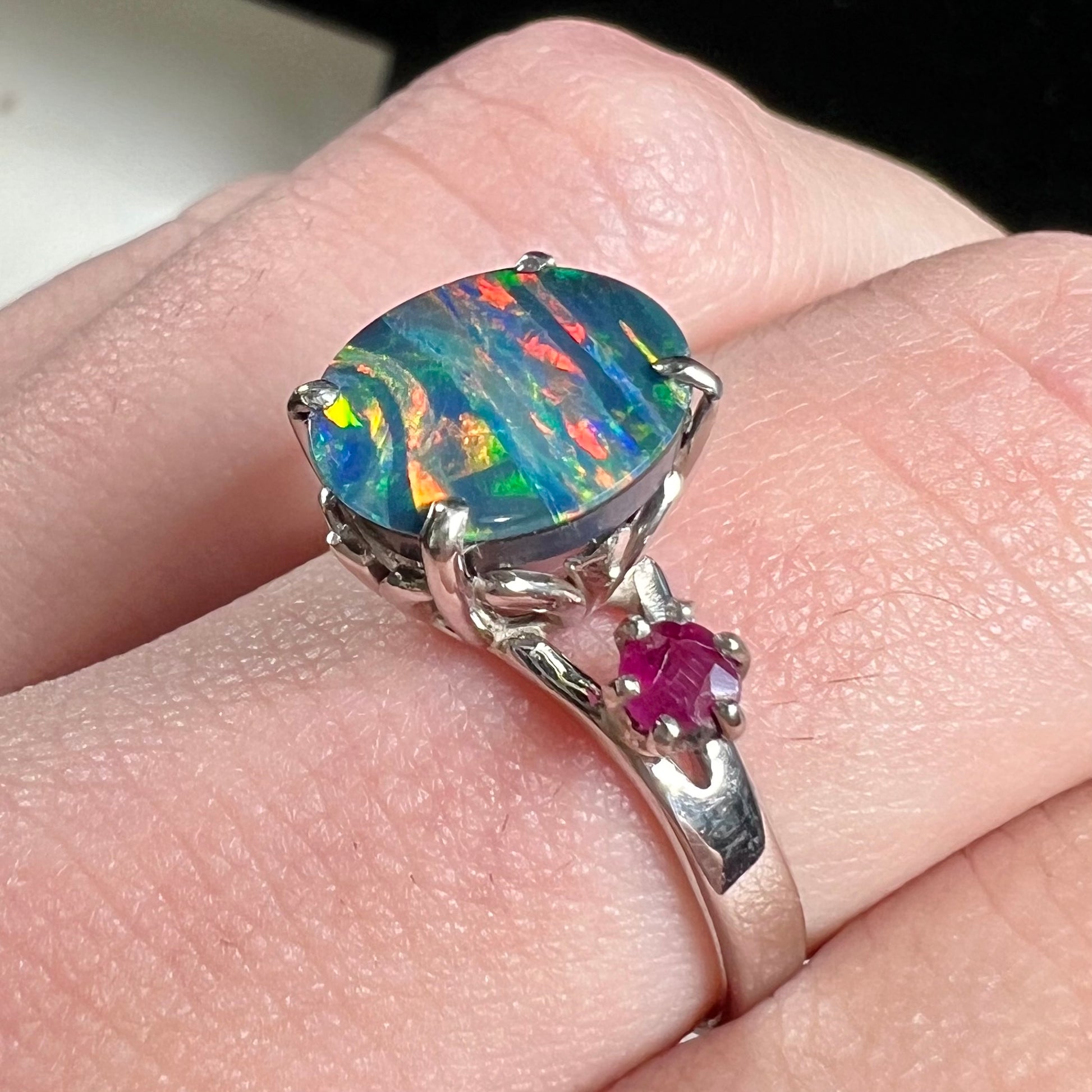 A ladies' 14kt white gold Australian black boulder opal doublet ring set with two round cut rubies.