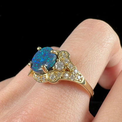 A ladies' 18kt yellow gold Lightning Ridge black opal and pave set diamond ring.