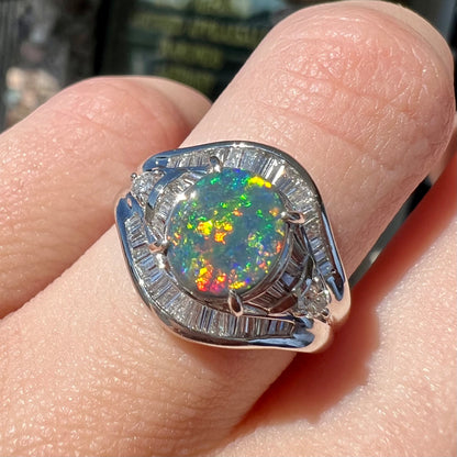 A platinum Lightning Ridge black opal ring set with baguette cut diamonds.  The opal is an oval cabochon cut.